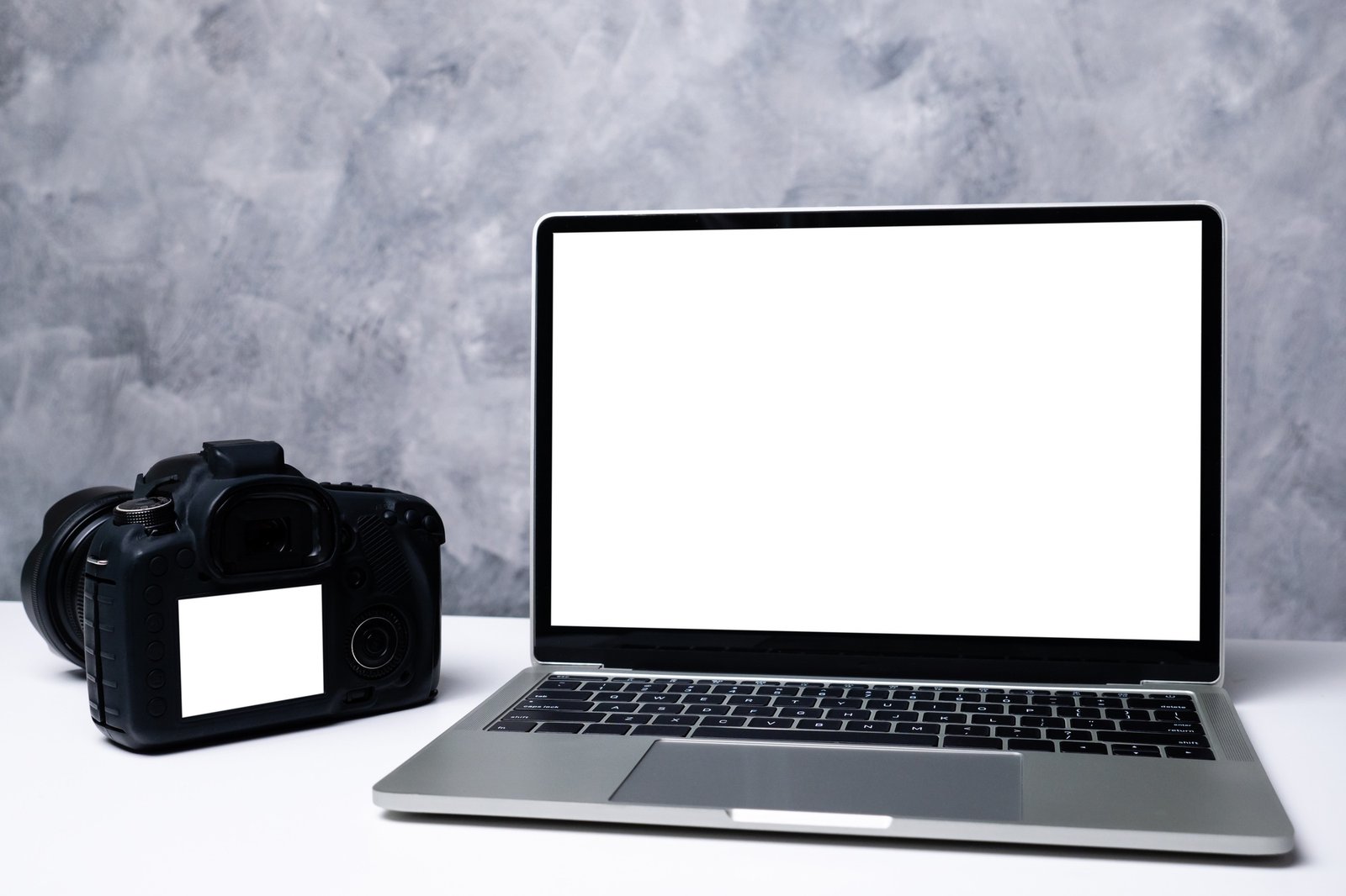 Un appareil photo numérique noir et un ordinateur portable d'ordinateur sur une table